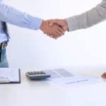 Real estate agent and customers shaking hands together celebrating finished contract after about