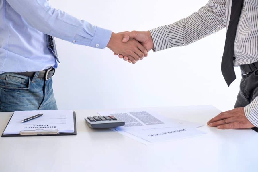 Real estate agent and customers shaking hands together celebrating finished contract after about