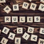 top view of rules word made of wooden blocks on brown surface